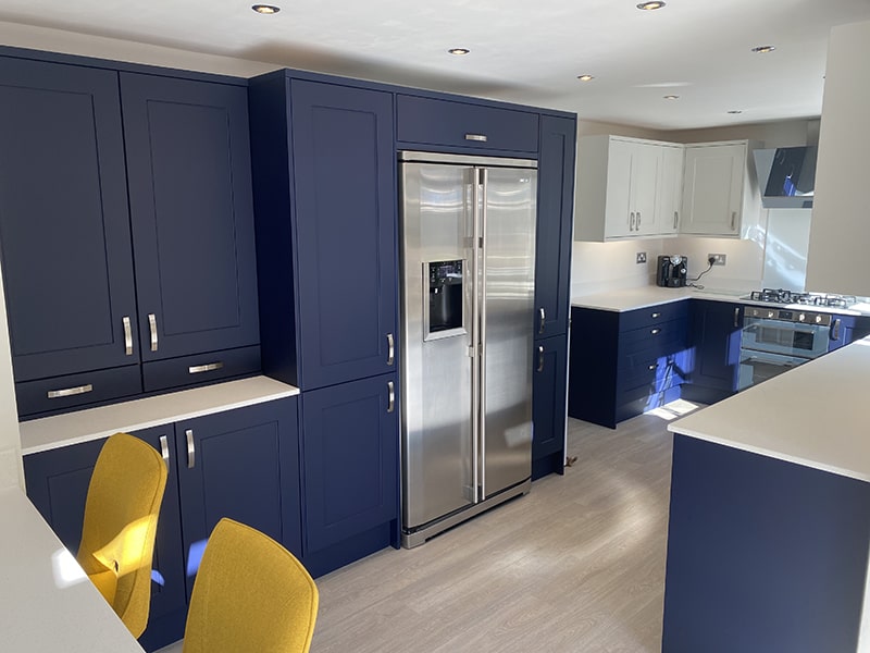 renovated kitchen with navy shaker doors and white work tops